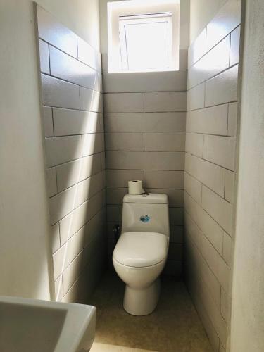 a small bathroom with a toilet and a window at Sacha Tourist Residence 2 in Mahébourg