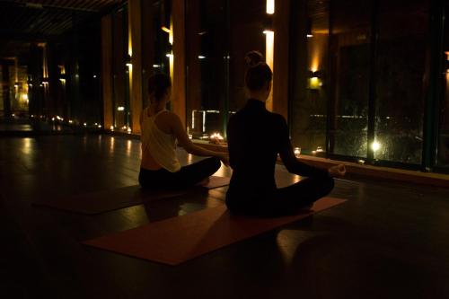 two people sitting in a yoga pose in a room with a window at Hotel Tri Studničky - Adult friendly in Demanovska Dolina