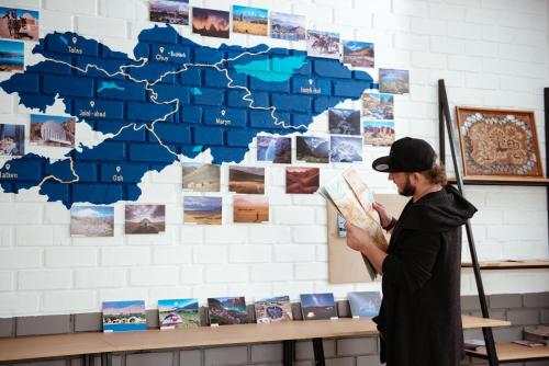 a man standing in front of a wall with a map at ololoFreelander Hostel&Coworking in Bishkek
