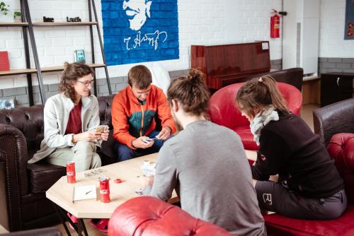 a group of people sitting around a coffee table at ololoFreelander Hostel&Coworking in Bishkek