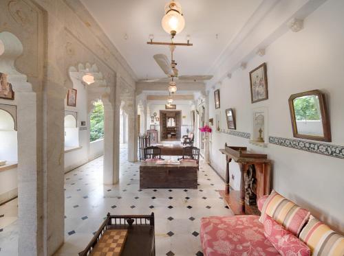 The Rawla Narlai - A Luxury Heritage Stay in Leopard Country في Nārlāi: غرفة معيشة مع أريكة وطاولة