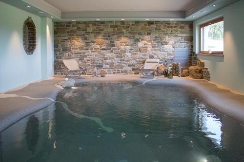 una gran piscina en una habitación con 2 sillas en Gigante Wine & Welcome, en Corno di Rosazzo