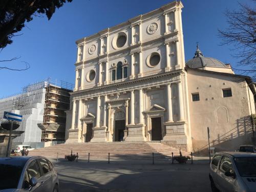 a large white building with a clock tower at B&B Oasi Vetoio in LʼAquila