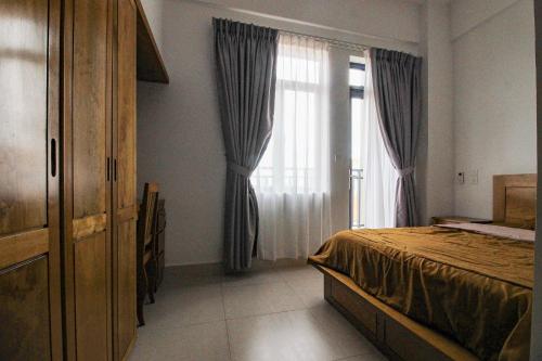 a bedroom with a bed and a large window at Ptas Tauch Residence in Phnom Penh