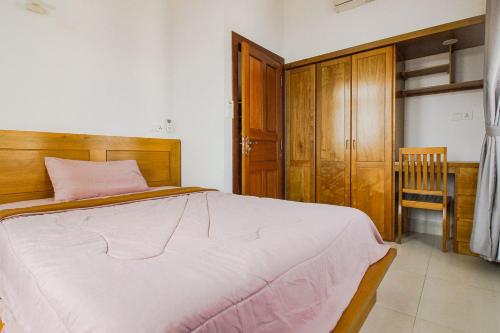 a bedroom with a large bed and a wooden cabinet at Ptas Tauch Residence in Phnom Penh