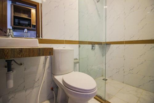 a bathroom with a toilet and a glass shower at Ptas Tauch Residence in Phnom Penh