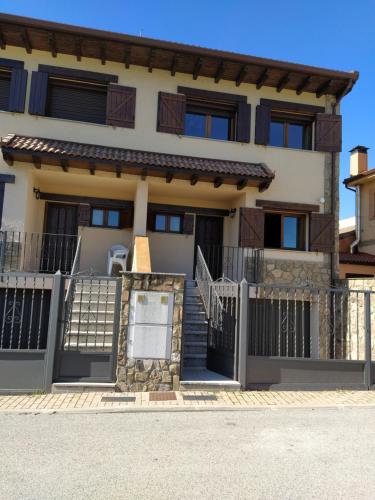 a house with a gate in front of it at Parque Sierra Norte in Rascafría