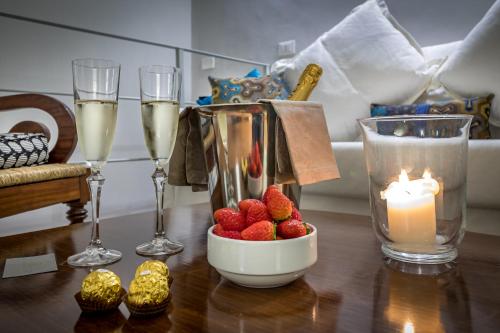 a table with a bowl of strawberries and glasses of champagne at Palazzo Ridolfi - Residenza d'Epoca in Florence