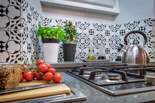 a kitchen with a stove and some tomatoes on a cutting board at Palazzo Ridolfi - Residenza d'Epoca in Florence