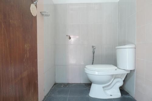 a bathroom with a white toilet in a room at RedDoorz Hostel @ Borobudur Street in Blimbing