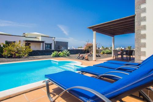 - un groupe de chaises longues bleues à côté de la piscine dans l'établissement Eslanzarote Villa Eleonor, Super Wifi, Heated Pool, Sat tv, à Playa Blanca
