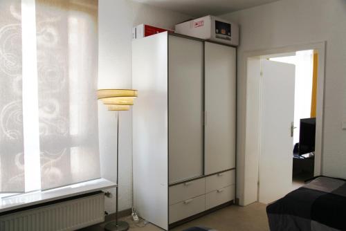 ein Schlafzimmer mit einem weißen Schrank und einem Fenster in der Unterkunft Apartment am Rhein in Wesseling