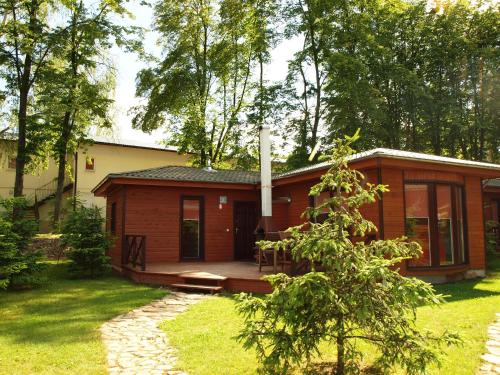 a small cabin in the woods with a porch at Lake Park Łagów in Łagów