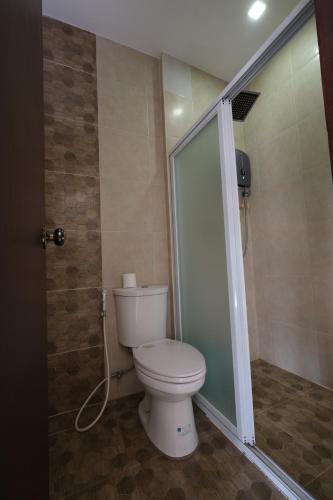 a bathroom with a toilet and a shower at Balai Carmela in Tuguegarao City