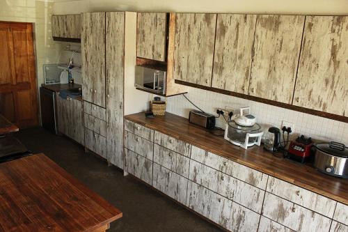 een keuken met houten kasten en een aanrechtblad bij African Adventures Accommodation in Joostenberg Vlakte