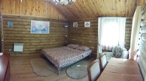 a bedroom with a bed in a wooden room at Zolotoy Bereg Hotel in Chernihiv