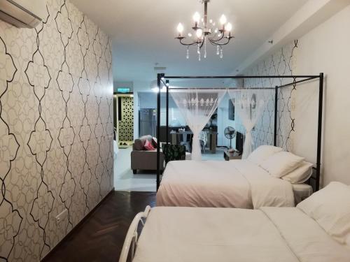 sypialnia z 2 łóżkami i żyrandolem w obiekcie Seaview Landmark Studio Homestay at Gurney 无敌海景套房 w mieście Tanjong Tokong