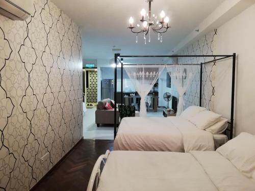 a bedroom with two beds and a chandelier at Seaview Landmark Studio Homestay at Gurney 无敌海景套房 in Tanjong Tokong