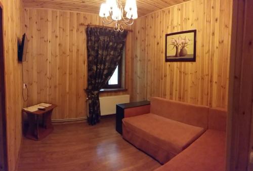 a living room with a couch and a window at Zolotoy Bereg Hotel in Chernihiv