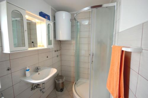 uma casa de banho com um lavatório e um chuveiro em Apartment Stefani em Njivice