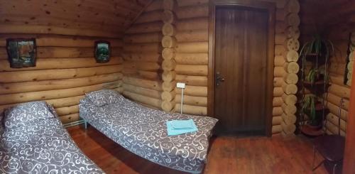 a room with a bed in a log cabin at Zolotoy Bereg Hotel in Chernihiv