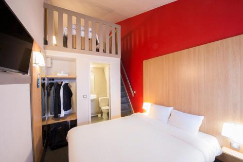 A bed or beds in a room at Kyriad Direct Poitiers - Gare du Futuroscope