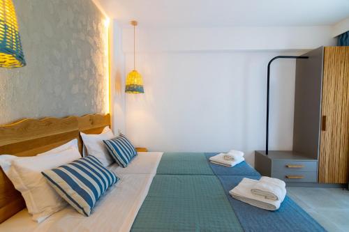a bedroom with a bed with two towels on it at Varkotopi Villas in Agios Pavlos