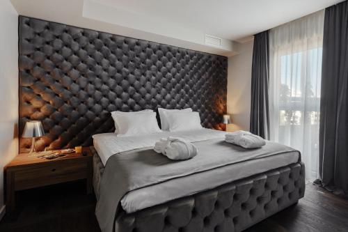 a bedroom with a large bed with a large padded headboard at Il Decameron Luxury Design Hotel in Odesa