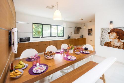a kitchen with a wooden table with food on it at The Mansion by Five Stay in Herzliyya B