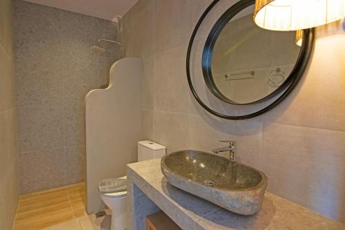 a bathroom with a stone sink and a mirror at Varkotopi Villas in Agios Pavlos
