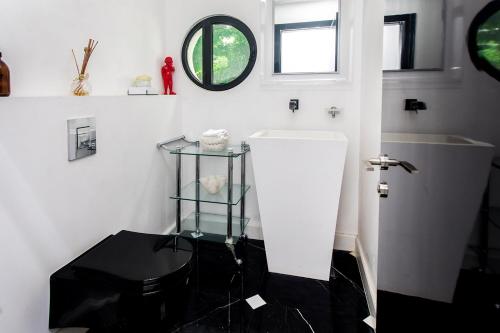 a white bathroom with a toilet and a mirror at The Mansion by Five Stay in Herzliyya B