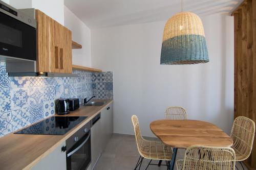 a kitchen with a wooden table and a dining room at Varkotopi Villas in Agios Pavlos