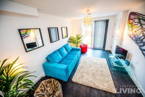 a living room with a blue couch and a tv at NEW Spacious Modern Townhouse Sleeps 12 Free Parking in Liverpool