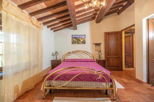Un dormitorio con una cama en una habitación con techos de madera. en Sarteano Country Villa, en Sarteano