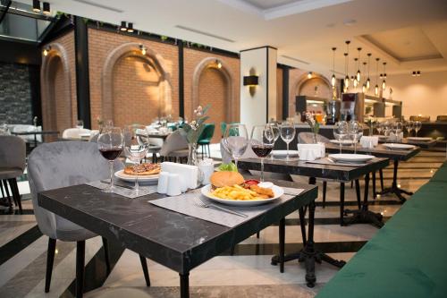 um restaurante com mesas com pratos de comida e copos de vinho em Emens hotel em Esmirna