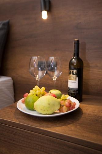 a plate of fruit and wine glasses on a table at Emens hotel in Izmir