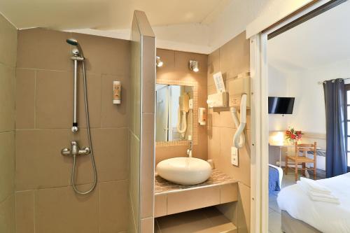 a bathroom with a sink and a shower in a room at Les Rizières in Saintes-Maries-de-la-Mer
