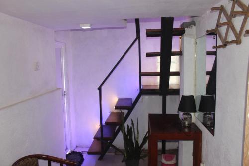 a purple room with a spiral staircase with a table at Bird's Nest by Natures Bliss in Ragama