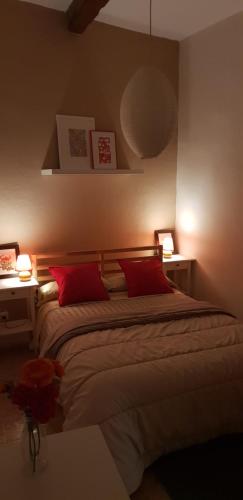 アラウリン・デ・ラ・トレにあるLa Casita de Silviaのベッドルーム1室(赤い枕とランプ2つ付)