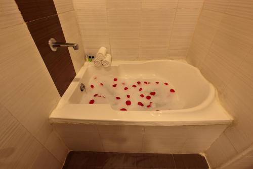 a bath tub with red hearts in it at Starlit Suites Bangalore in Bangalore