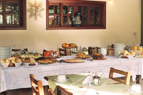 una mesa con pan y otros alimentos. en Hotel Pousada São Rafael en Passa Quatro