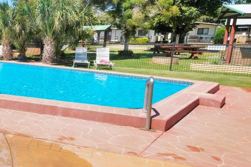 uma piscina num quintal com mesa e cadeiras em BIG4 Toowoomba Garden City Holiday Park em Toowoomba