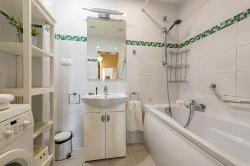 een badkamer met een bad, een wastafel en een bad bij P&O Apartments Old Town in Warschau