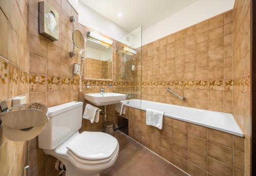 łazienka z toaletą, umywalką i wanną w obiekcie Hotel Bellevue Wien w Wiedniu