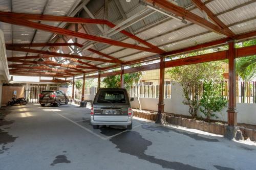 a parking lot with a car parked in it at RedDoorz Plus Syariah at Alam Raya Hotel in Palu
