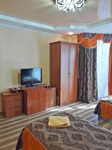 a hotel room with a television and a bed at Kristall Hotel in Bosteri