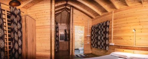 Munroe Island的住宿－GreenChromide Homestays，一间木制客房,配有一张位于客房内的床