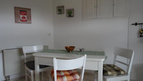 a dining room table with two chairs and a green table and chairsktop at Ferienwohnung bei Erfurt in Gebesee