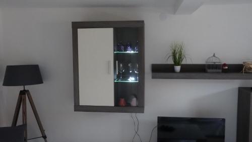 a mirror on a wall with a shelf with bottles at Ferienwohnung bei Erfurt in Gebesee