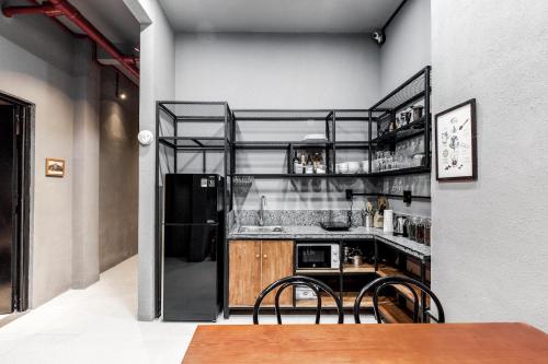 a kitchen with a table and chairs in a room at CIRCADIAN Industrial Studios on Nguyen Hue in Ho Chi Minh City